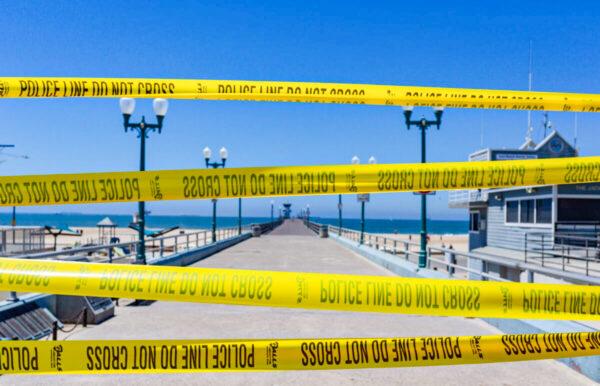 Police tape blocks entry to a pier in Seal Beach, Calif., on July 4, 2020. (John Fredricks/The Epoch Times)