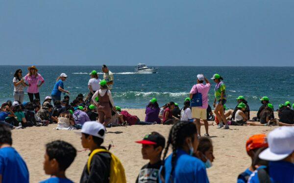 Elementary school students celebrating Kids Ocean Day work together in cleaning Huntington State Beach in Huntington Beach, Calif., on May 31, 2022. (John Fredricks/The Epoch Times)