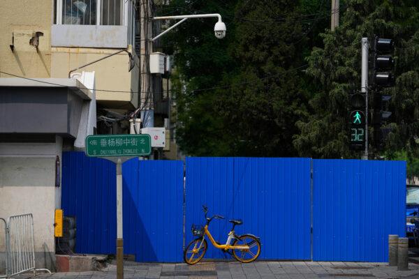 A bicycle is parked in front of a barricaded fence of a locked-down residential complex in Beijing on April 29, 2022. (Andy Wong/AP Photo)