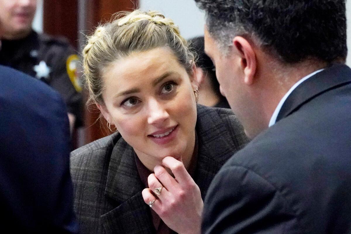 Actress Amber Heard talks to her attorneys during a break, in the courtroom at the Fairfax County Circuit Court in Fairfax, Va., on May 2, 2022. (Steve Helber/Pool via AP)