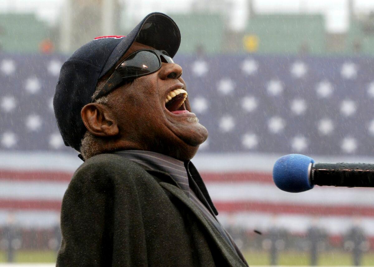 Ray Charles sings "America The Beautiful" in the rain at Fenway Park in Boston on April 11, 2003. (Winslow Townson/AP Photo)