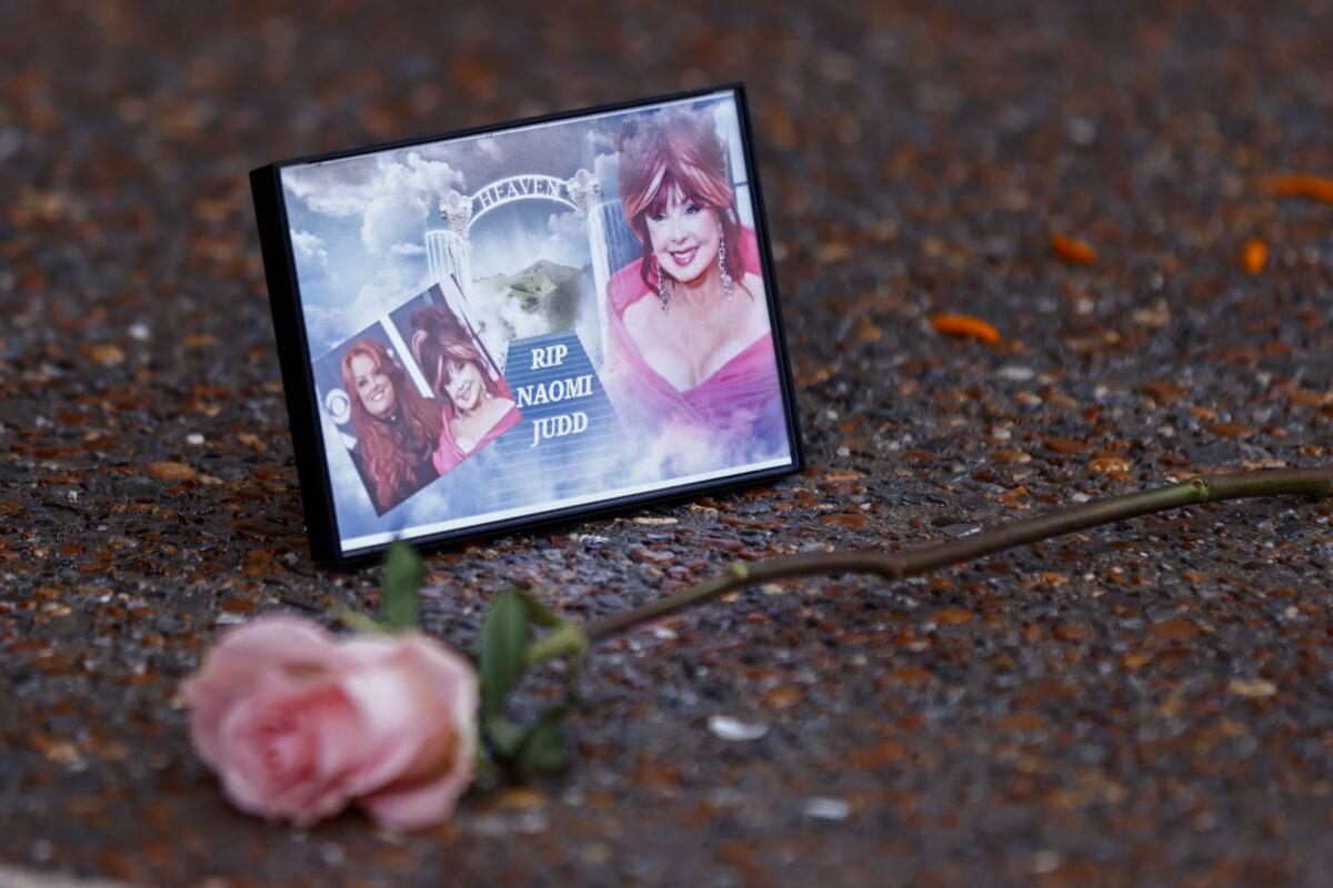 A photograph of Naomi Judd lays with a rose outside the Country Music Hall of Fame before the medallion ceremony in Nashville, Tenn., on May 1, 2022. (Wade Payne/Invision/AP)