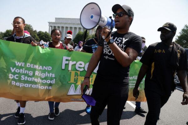 Voting rights activists participate in a “Freedom Friday March” protest as they march toward Ronald Reagan Washington National Airport on Memorial Bridge in Washington, on Aug. 6, 2021. (Alex Wong/Getty Images)