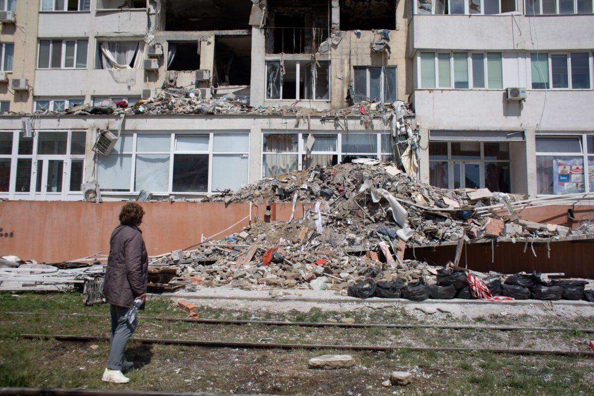 A resident whose apartment was destroyed by a missile strike on a residential building looks at the work of a rescue team in Odesa, Ukraine, on April 25, 2022. (Anastasia Vlasova/Getty Images)