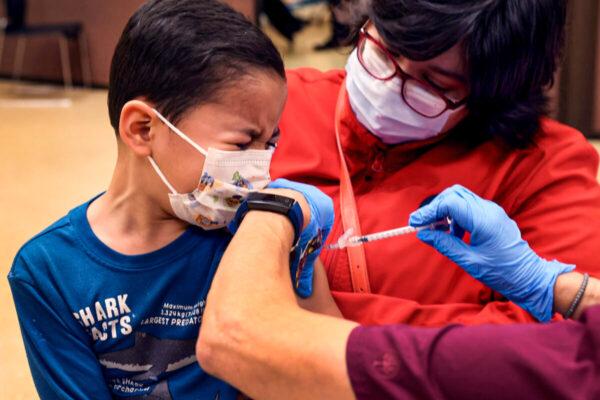 A first grade student, 6-year-old Leonel Campos, receives a COVID-19 vaccine at Arturo Velasquez Institute in Chicago, Ill., on Nov. 12, 2021. (Scott Olson/Getty Images)
