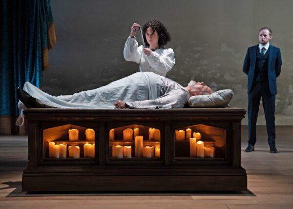 Alejandra Escalante as Helen administers a miraculous cure to Francis Guinan as the ailing King of France, under the watchful eyes of Jacob Mundell (R) as the King’s Attendant in Chicago Shakespeare Theater’s production of “All’s Well That Ends Well.” (Liz Lauren)