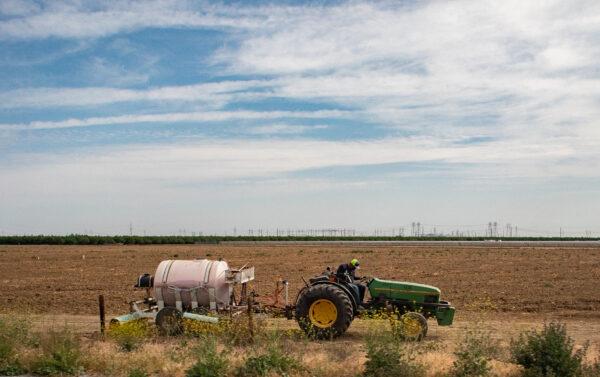 A farmer uses a tractor outside of Sacramneto, Calif on April 18, 2022. (John Fredricks/The Epoch Times)