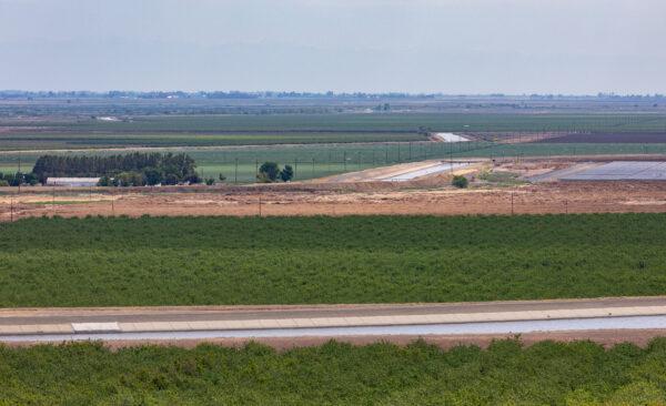 The California Aquaduct (foreground) sits adjacent to farmland outside of Sacramento, Calif., on April 18, 2022. (John Fredricks/The Epoch Times)