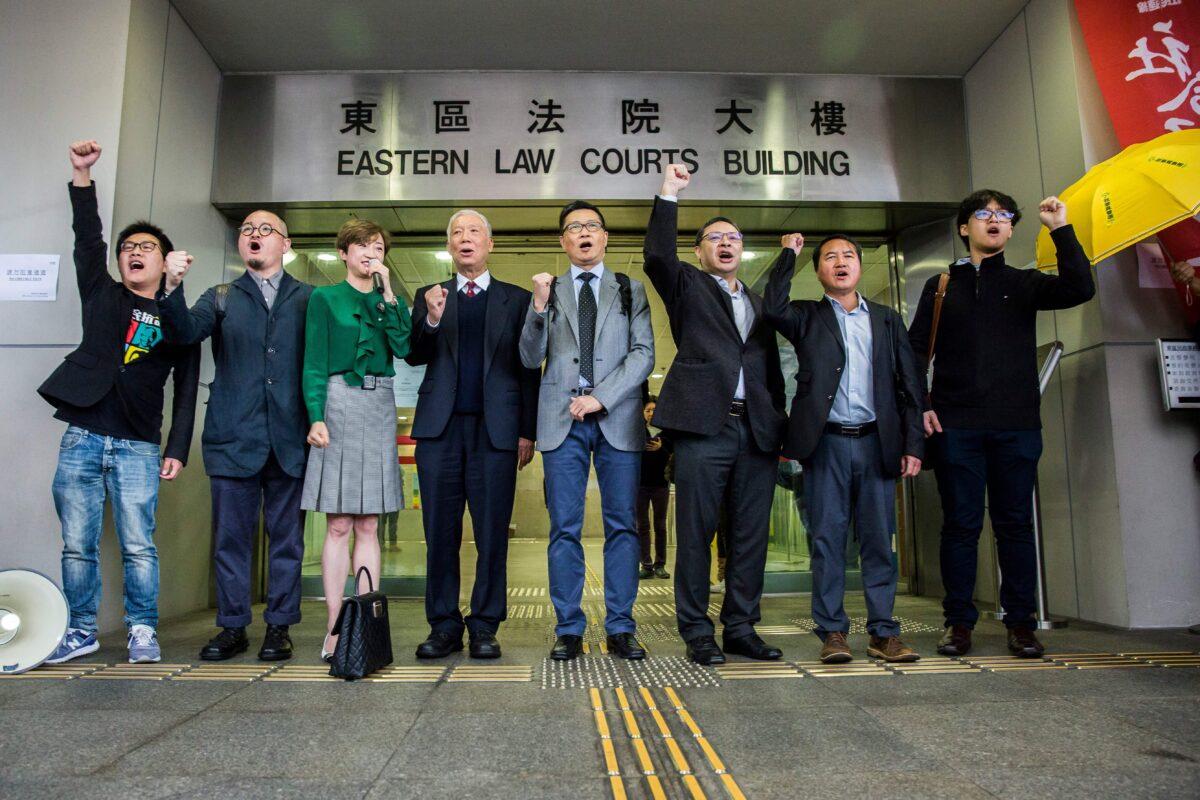(L-R) League of Social Democrats vice-chairmen Raphael Wong, Lawmaker Shiu Ka-Chan, lawmaker Tanya Chan, reverend Chu Yui-ming, academic Chan Kin-man, academic Benny Tai Yiu-ting, former lawmaker Lee Wing-tat, and former student leader Tommy Cheung Sau-yin stand outside the Eastern District Court on March 30, 2017.  (Isaac Lawrence/AFP via Getty Images)