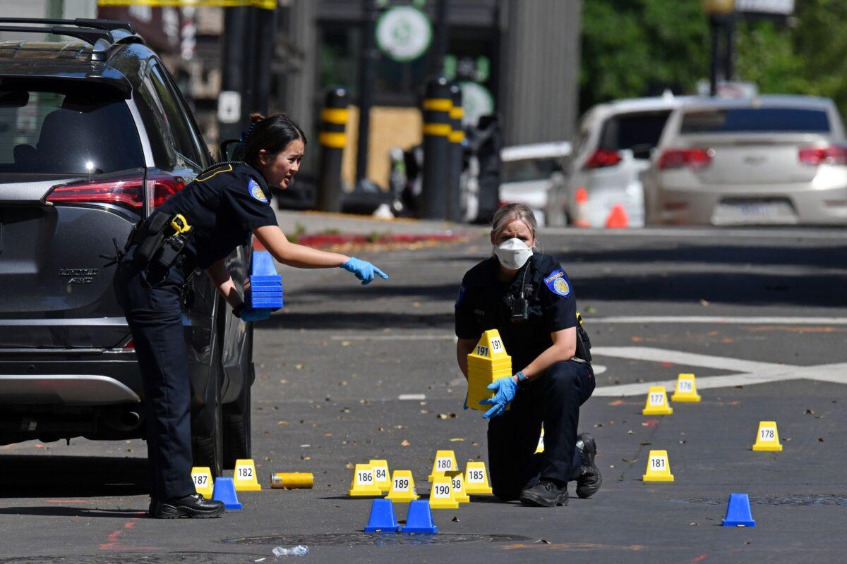 Police crime scene investigators place evidence markers on 10th Street at the scene of a mass shooting in Sacramento, Calif., on April 3, 2022. (Jose Carlos Fajardo/Bay Area News Group/TNS)
