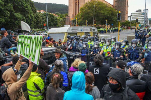 Police stand guard as protesters against COVID-19 vaccine mandates and restrictions gather near parliament grounds in Wellington, New Zealand, on March 2, 2022. (Dave Lintott/AFP via Getty Images)