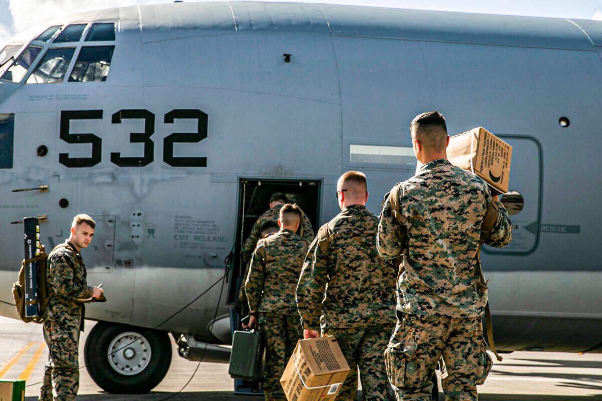 U.S. Marines and sailors with Combat Logistics Regiment 3, 3d Marine Logistics Group, board a U.S. Air Force C-130 Hercules at Kadena Air Base, Japan, on Dec. 6, 2021. (U.S. Marine Corps photo by Sgt. Hailey D. Clay)