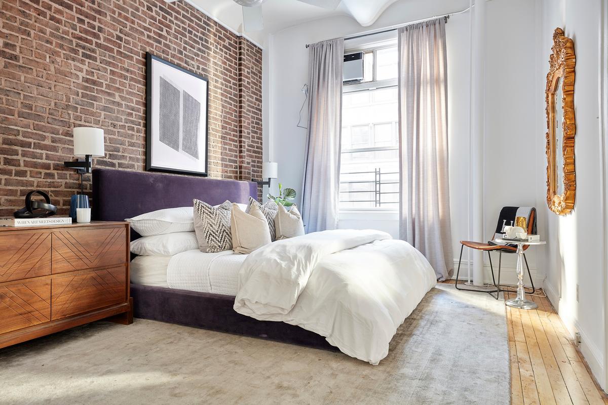 An exposed brick wall serves as the focal point in this bedroom. (Scott Gabriel Morris/TNS)