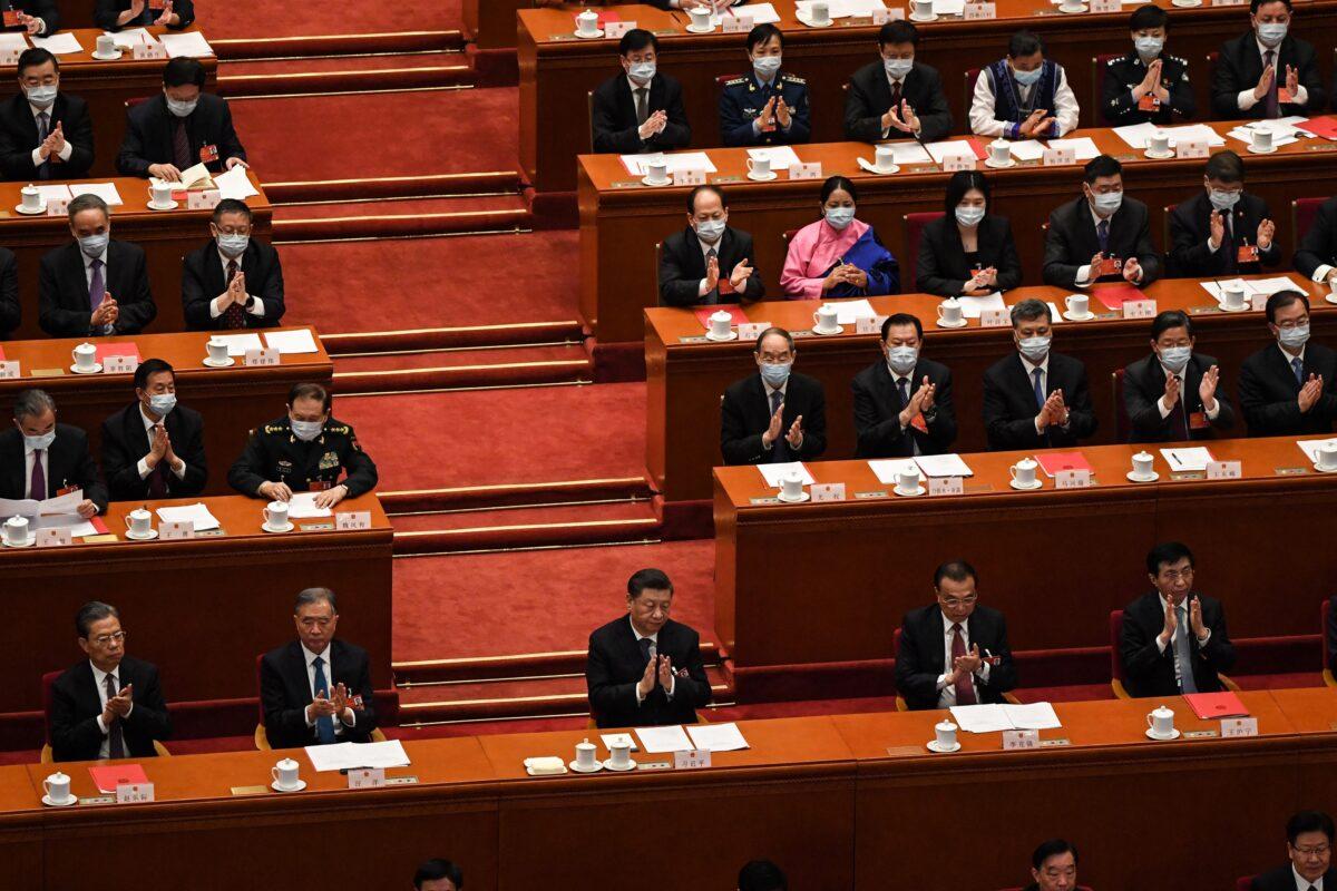 Chinese Communist Party leader Xi Jinping and other leaders applaud during the closing session of the rubber-stamp legislature's conference at the Great Hall of the People in Beijing on March 11, 2022. (Leo Ramirez/AFP via Getty Images)