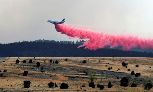 A slurry bomber dumps the fire retardant between the Calf Canyon/Hermit Peak Fire and homes on the westside of Las Vegas, on May 3, 2022. (Eddie Moore/The Albuquerque Journal via AP)