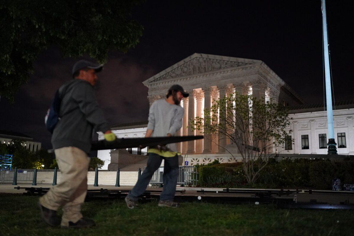 Workers move fencing to the Supreme Court in Washington late May 4, 2022. (Stefani Reynolds/AFP via Getty Images)