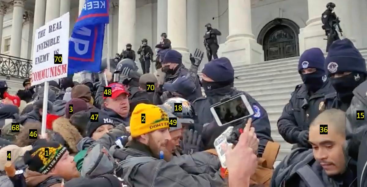More than a dozen 'suspicious actors' flagged by defense attorneys line up on the east steps of the U.S. Capitol, shortly before they pushed past police and climbed to the Columbus Doors on Jan. 6, 2021. (Attorney Brad Geyer/Screenshot via The Epoch Times)
