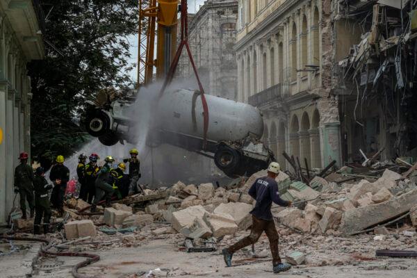 Firefighters spray a tanker truck with water in order to cool it down as they remove it from the site of a deadly explosion that destroyed the five-star Hotel Saratoga, in Havana, Cuba, on May 6, 2022. (Ramon Espinosa/AP Photo)