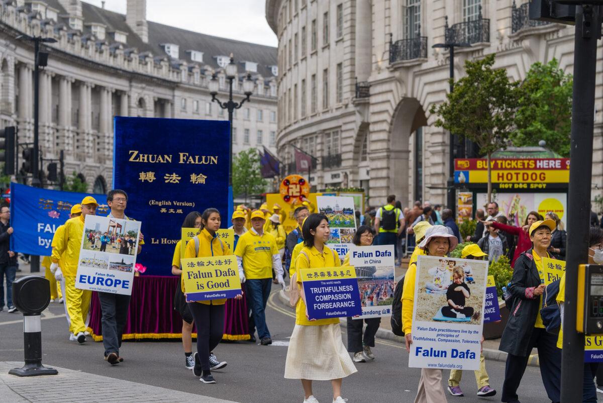 A parade in celebration of Falun Dafa, including a float depicting "Zhuan Falun," the principal text of the practice, passes through central London on May 7, 2022. (Yan Ning/The Epoch Times)
