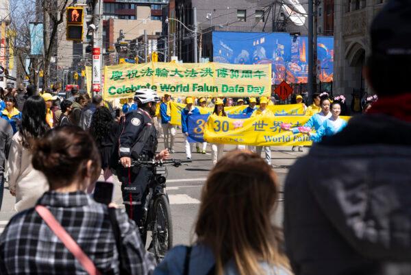 Torontonians looked on as Falun Gong adherents paraded through the city's downtown area on May 7, 2022, in commemoration of the 30th anniversary of the spreading of the practice around the world. (Evan Ning/The Epoch Times)