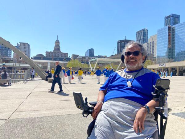 Toronto resident John followed the Falun Gong parade across downtown to celebrate the 30th anniversary of the spreading of the practice, on May 7, 2022. (Xinxin Teng/The Epoch Times)