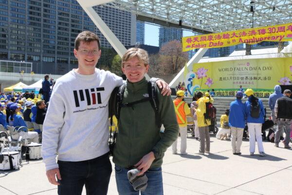 Jordan Schmidt and his friend Jason watched a dance and music performances by adherents of Falun Gong who were celebrating the 30th anniversary of the spreading of the practice, in downtown Toronto on May 7, 2022. (Andrew Chen/The Epoch Times)