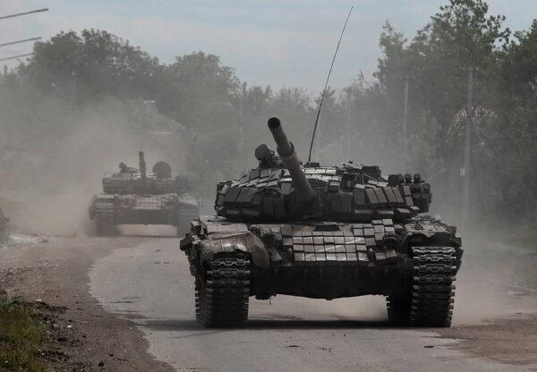 Tanks of pro-Russian troops drive along a street during the Ukraine–Russia conflict in the town of Popasna in the Luhansk Region, Ukraine, on May 26, 2022. (Alexander Ermochenko/Reuters)