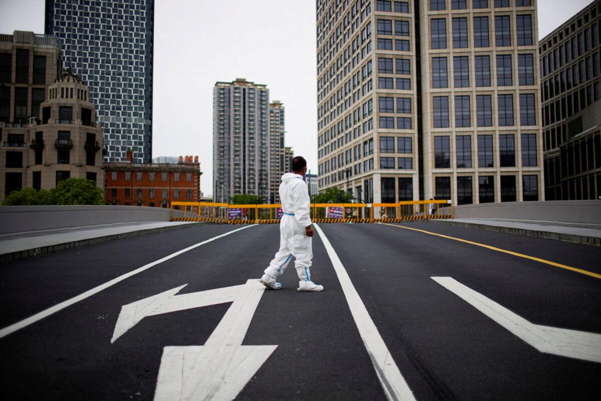 A worker in a protective suit walks on a closed bridge during lockdown in Shanghai, China, May 18, 2022. (Aly Song/File Photo/Reuters)