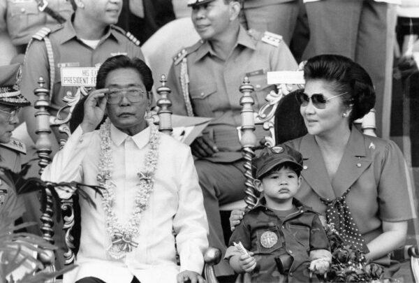 President Ferdinand Marcos and his wife Imelda appear on Nov. 15, 1985, before some 35,000 college students undergoing a two-year compulsory military training in Manila. Ferdinand Marcos Jr. sits with his mother. (Romeo Gacad/AFP via Getty Images)