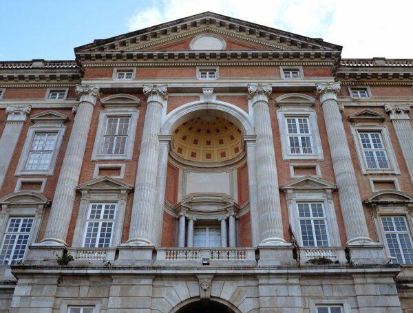 The palace’s colossal Neoclassical façade features four mighty columns, a pedimented frontispiece, and a domed apse. A long balustrade lines the roof, interrupted only by this central entranceway. (Livioandronico/CC BY-SA 4.0)