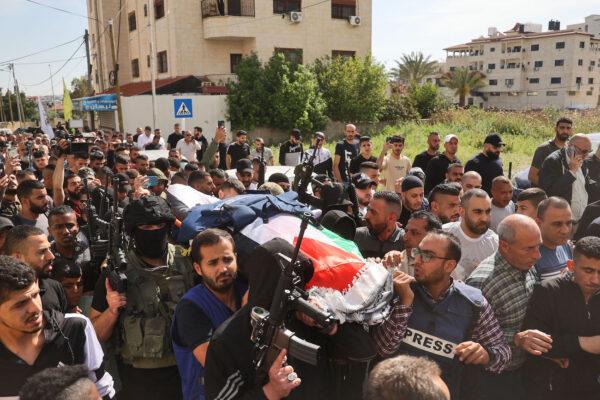  Mourners and masked armed men carry the body of veteran Al Jazeera Palestinian journalist Shireen Abu Akleh, who was fatally shot as she covered a raid on the West Bank's Jenin refugee camp as her body is transferred to Jerusalem from Jenin ahead of her funeral, on May 11, 2022. (Jaafar Ashtiyeh/AFP via Getty Images)
