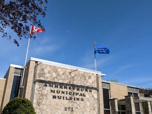 A Falun Dafa flag is raised on the Amherstburg Municipal building on May 9, 2022. (Arek Rusek/The Epoch Times)