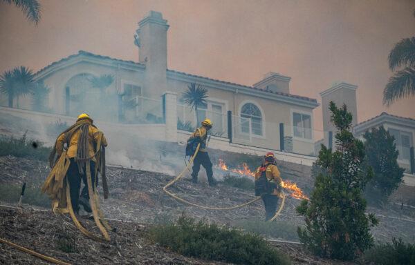 Firefighters work on extinguishing the Coastal Fire in Laguna Niguel, Calif., on May 11, 2022. (John Fredricks/The Epoch Times)