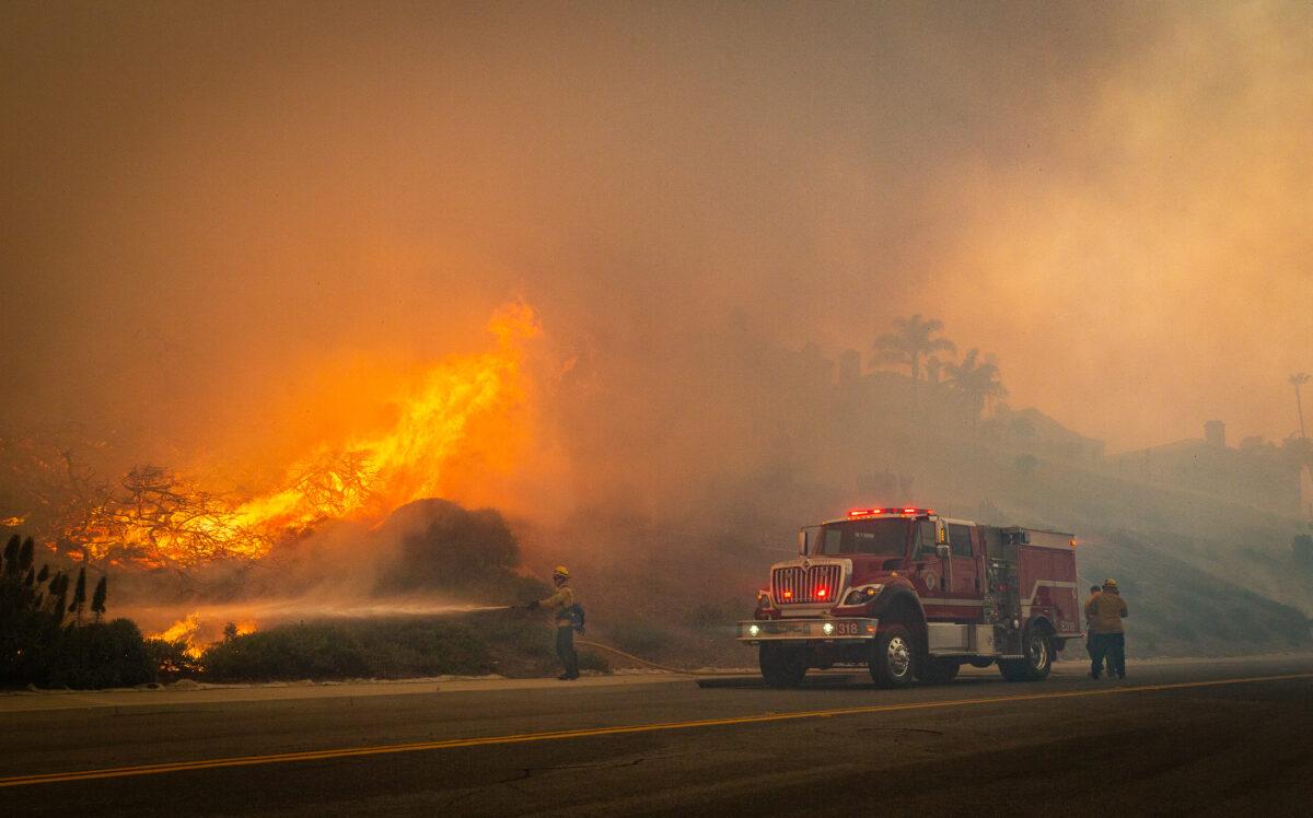 Firefighters work on extinguishing the Coastal Fire in Laguna Niguel, Calif., on May 11, 2022. (John Fredricks/The Epoch Times)