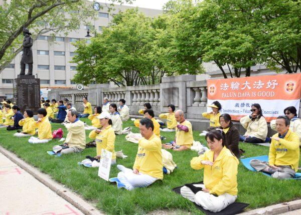 Falun Gong practitioners practicing the meditation exercise outside Trenton City Hall on May 12, 2022. (Jing Song/Epoch Times)