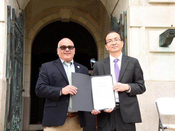New Jersey capital city Trenton's Mayor (L) presents a Falun Dafa Day Proclamation to a representative of the New Jersey Falun Dafa Association on May 12, 2022. (Jing Song/Epoch Times)