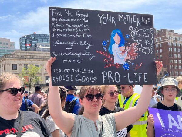 A demonstrator holds a sign as thousands of pro-life supporters gather for a "March for Life" rally in Ottawa on May 12, 2022. (Annie Wu/The Epoch Times)