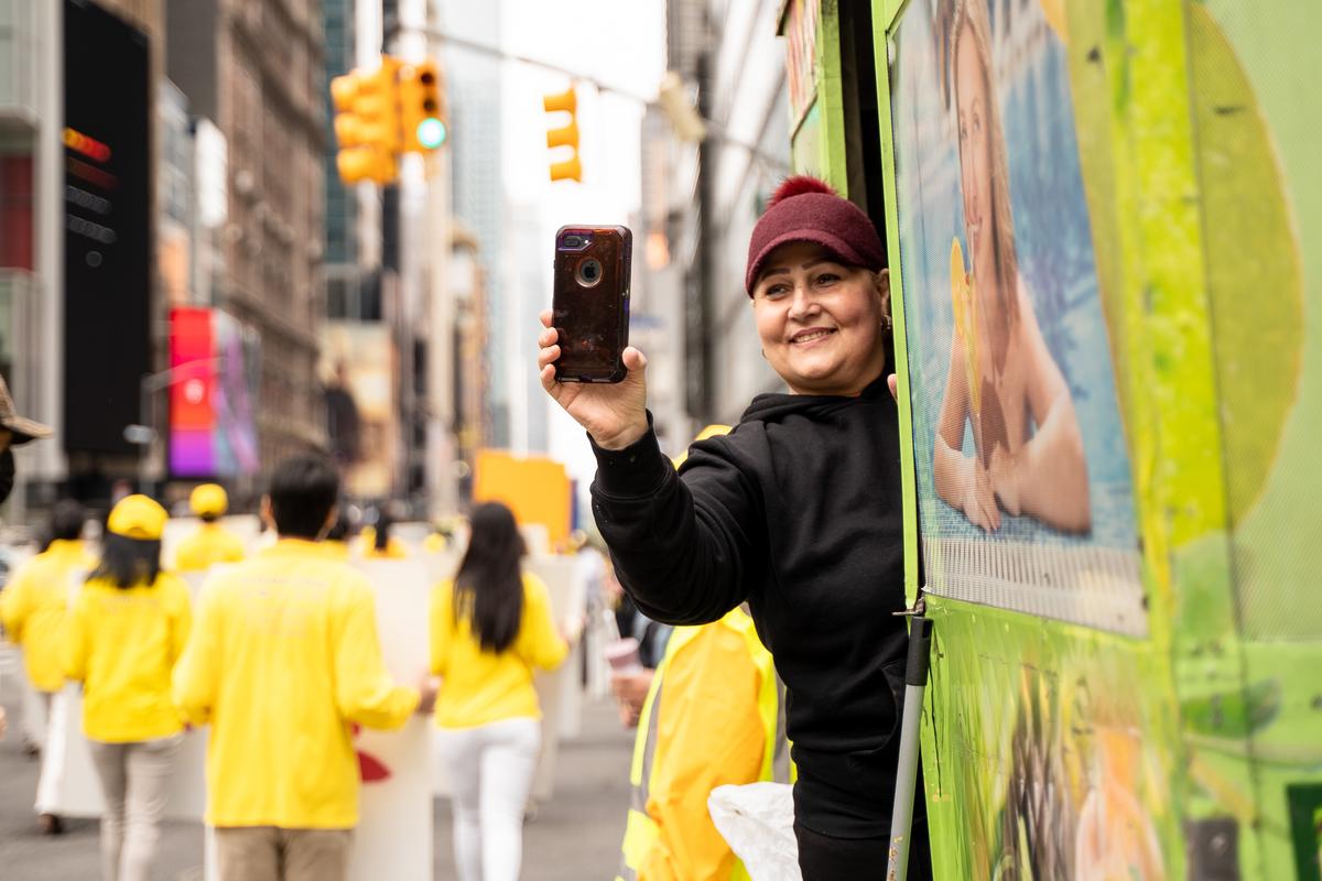 Pedestrians watch as Falun Gong practitioners take part in a parade marking the 30th anniversary of its introduction to the public, in Manhattan, New York, on May 13, 2022. (Samira Bouaou/The Epoch Times)