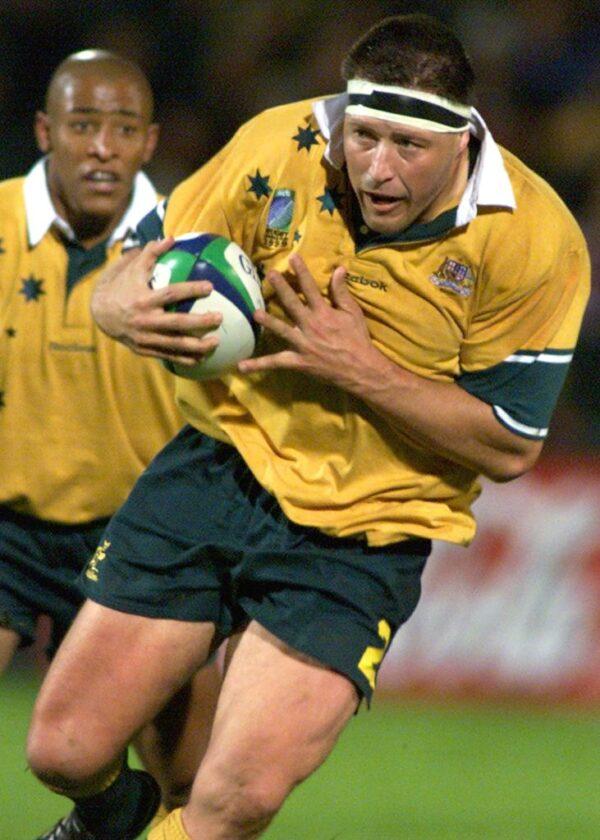 Australian hooker Phil Kearns leads a charge followed by teammate George Gregan in their clash against Romania at the 1999 Rugby World Cup at Ravenhill Park in Belfast on October 3, 1999. (Photo by WILLIAM WEST/AFP via Getty Images)