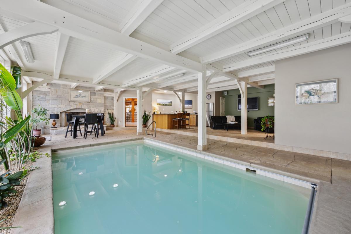 The indoor pool house has its own bar, dining, sitting, bath, and changing areas. (Baird & Warner)