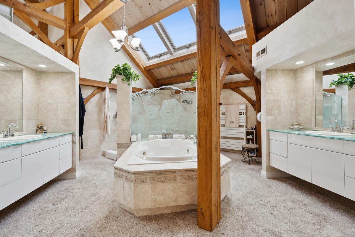Here you can see how the skylights are used to bathe the interiors with ambient light. The master suite bath is a spacious affair with whirlpool, his and hers vanities, and other luxury features. (Baird & Warner)
