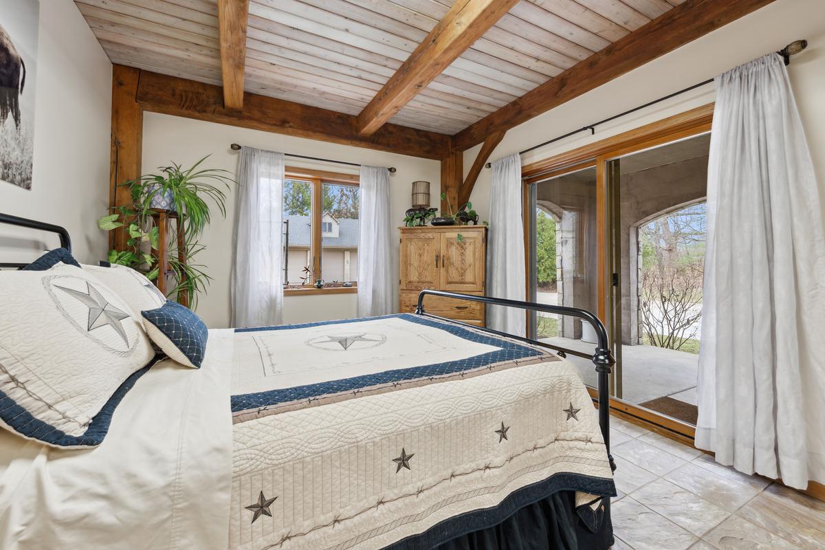 A downstairs guest bedroom opens onto its own patio facing the paddock, ponds, barn, and other outbuildings. (Baird & Warner)