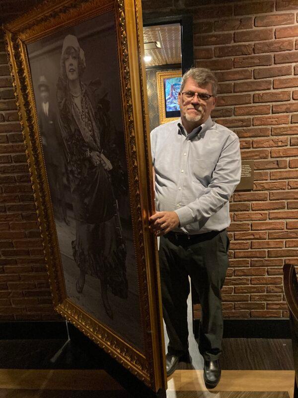 Geoff Schumacher, vice president of exhibits and programs at The Mob Museum in Las Vegas, emerges from a "speakeasy" hidden behind a large painting on the museum's basement level. (Allan Stein/The Epoch Times)
