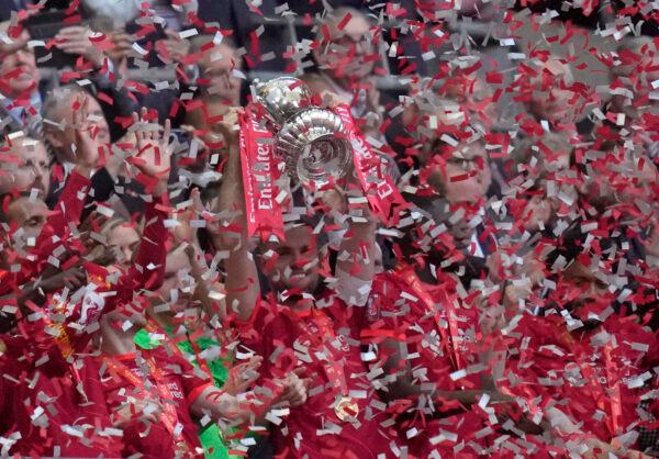 Liverpool's Jordan Henderson lifts the trophy and celebrates after winning the English FA Cup final soccer match between Chelsea and Liverpool, at Wembley stadium in London on May 14, 2022. (Kirsty Wigglesworth/AP Photo)