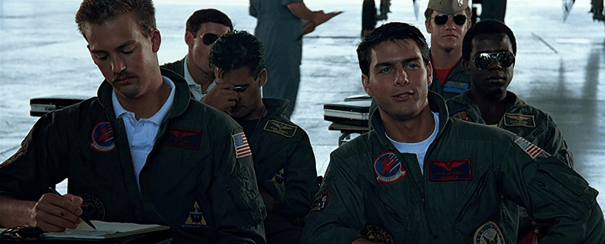 (Front row): Goose (Anthony Edwards, L), and Maverick (Tom Cruise) engage in some slightly hostile teasing of their flight instructor in "Top Gun: Maverick." (Paramount Pictures)
