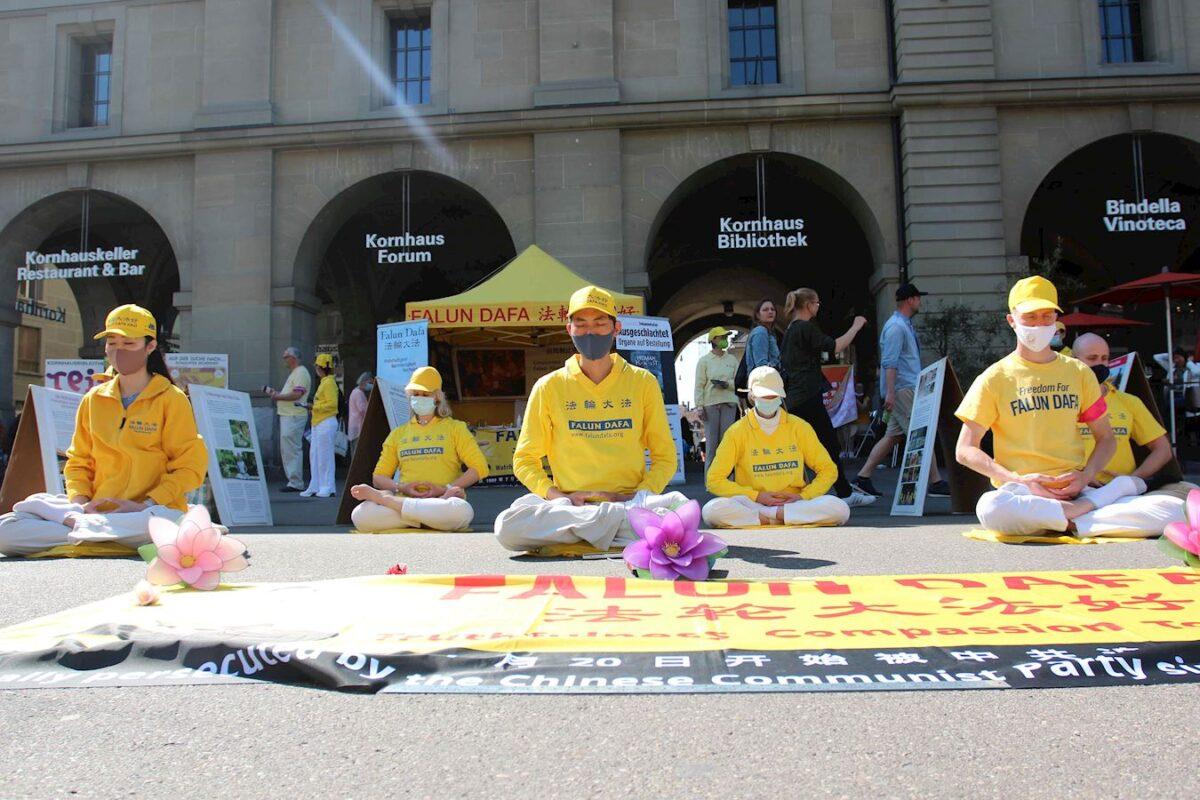 Falun Dafa practitioners perform the practice's sitting meditation exercise in a peaceful rally at Kornhausplatz in Bern, Switzerland, on April 25, 2021. (Minghui.org)
