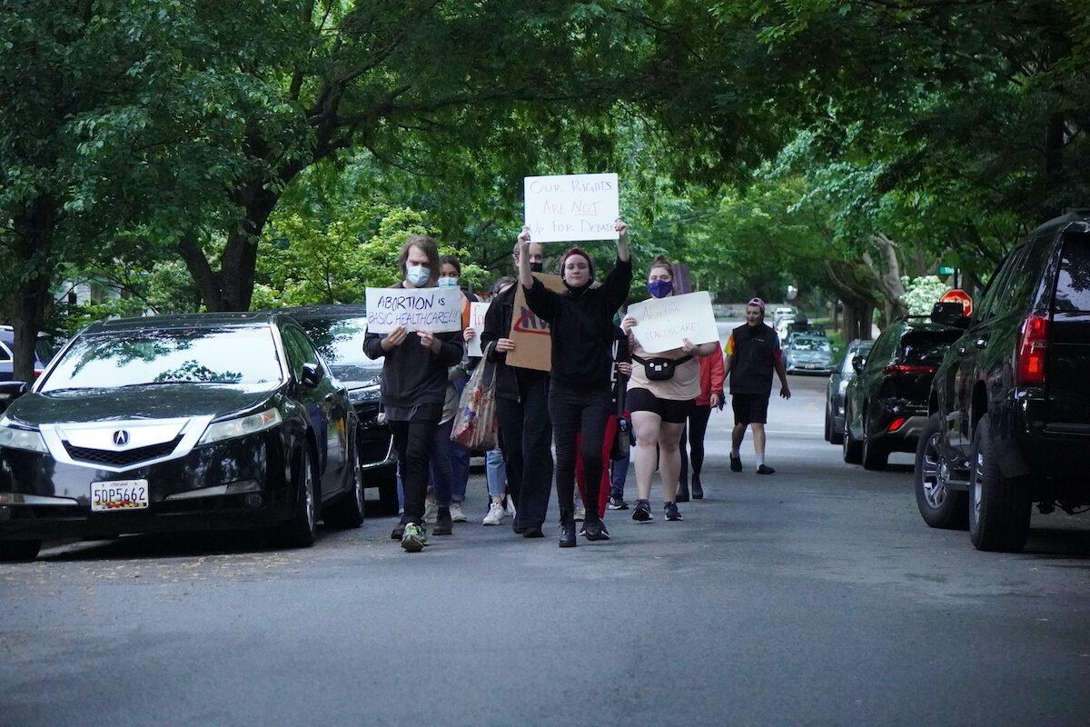 A column of 20 protesters marches through the neighborhood of Justice Brett Kavanaugh and Justice John Roberts in Chevy Chase, Md., on May 15, 2022. (Jackson Elliott/The Epoch Times)