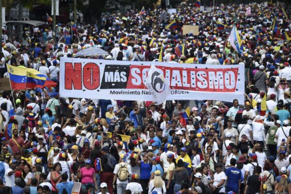 Opposition supporters hold a banner reading "No More Socialism" during a gathering with Venezuelan opposition leader Juan Guaido, in Caracas, on Feb. 2, 2019. Guaido called for early elections as international pressure increased on President Nicolas Maduro to step down. (Juan Barreto/AFP via Getty Images)