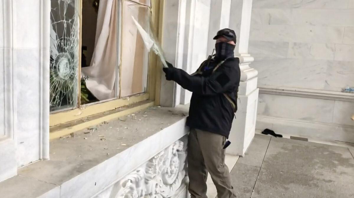 A suspicious actor vandalized a Capitol window on Jan. 6, 2021. He has not been placed on the FBI wanted list nor arrested or charged. (Bobby Powell/Screenshot by The Epoch Times)