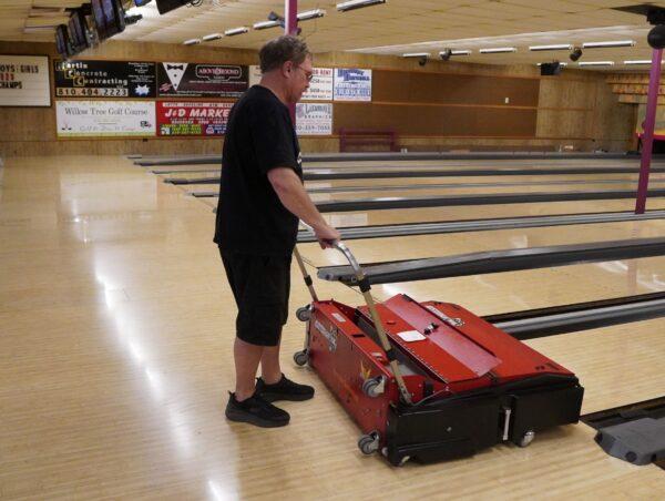 Fred Kautz runs the lane oiler at Kautz Shore Lanes in Lexington, Mich., on May 13, 2022. (Steven Kovac/The Epoch Times)